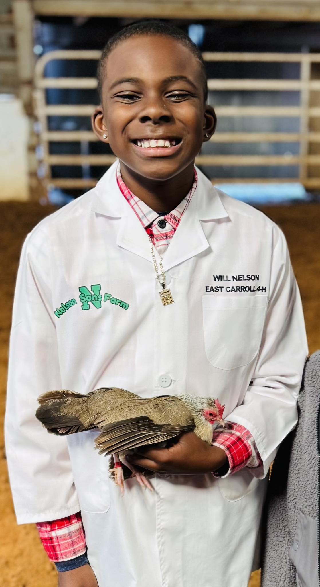 A boy holding a chicken.